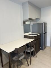 Compact modern kitchen area with dining table and chairs