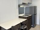 Compact modern kitchen area with dining table and chairs