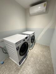 Laundry room with washing machines and air conditioner