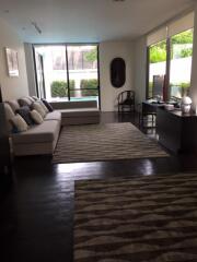 Modern living room with large windows and dark wooden flooring