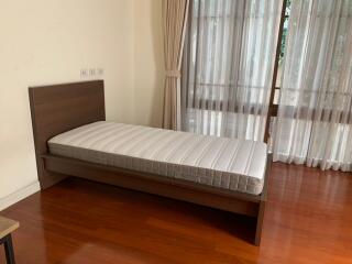 Simple bedroom with single bed and wooden flooring