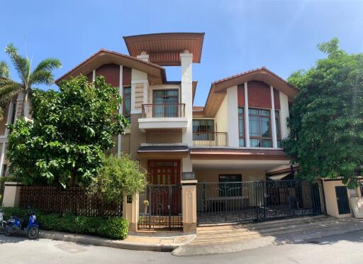 Two-story residential house with a front yard, balcony, and a gated entrance