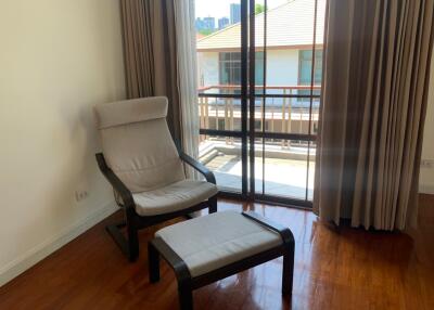 Cozy corner with armchair and ottoman next to large windows