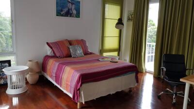 Bedroom with bed, windows, and chair