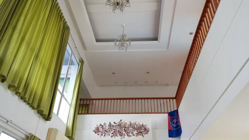 High ceiling living room with chandelier and large window