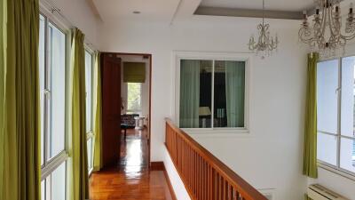 Hallway with large windows and green curtains