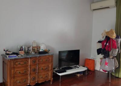 Living room with a wooden dresser, television, and balcony