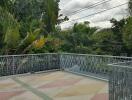 Rooftop terrace with ornate metal railing and lush green vegetation