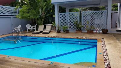 Outdoor swimming pool with lounge chairs and plants