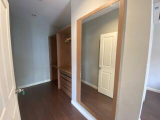 Walk-in closet with large mirror and wooden finishings