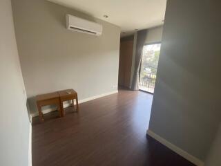 Empty modern living area with wooden floor and large window