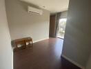 Empty modern living area with wooden floor and large window