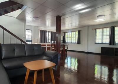 Spacious living room with staircase and large windows