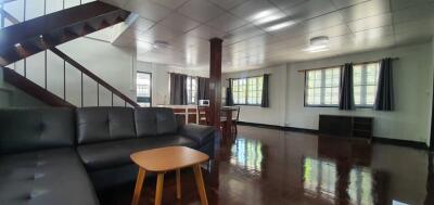 Spacious living room with staircase and large windows