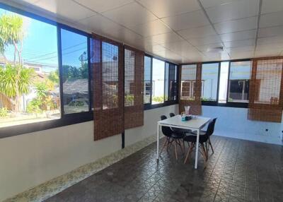 Sunlit enclosed patio with dining table and chairs