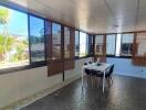 Sunlit enclosed patio with dining table and chairs