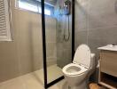 Modern bathroom with glass shower door and grey tiles