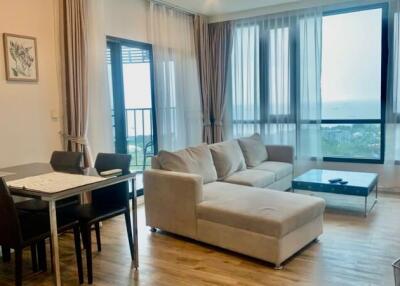 Living room with dining area, large window with a seaside view