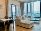 Living room with dining area, large window with a seaside view