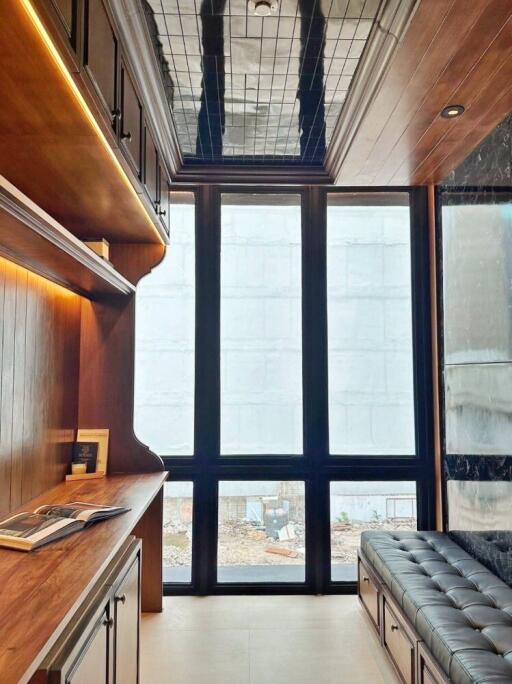 Well-lit home office with wooden furniture and high ceiling