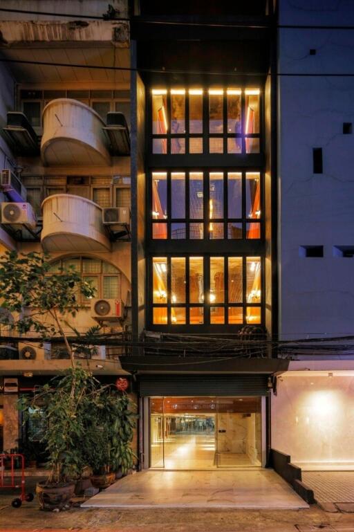 Illuminated facade of a modern multi-story building with floor-to-ceiling windows