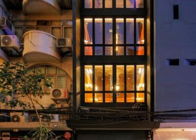 Front view of a modern apartment building with illuminated windows