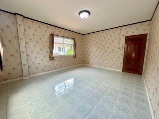 Empty bedroom with floral wallpaper and tiled floor