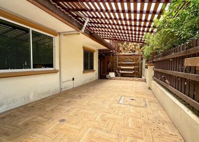 Covered outdoor patio with wooden flooring and pergola shade