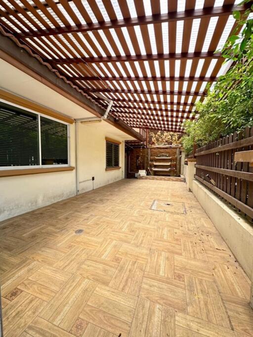 Covered outdoor patio with wooden flooring and pergola shade