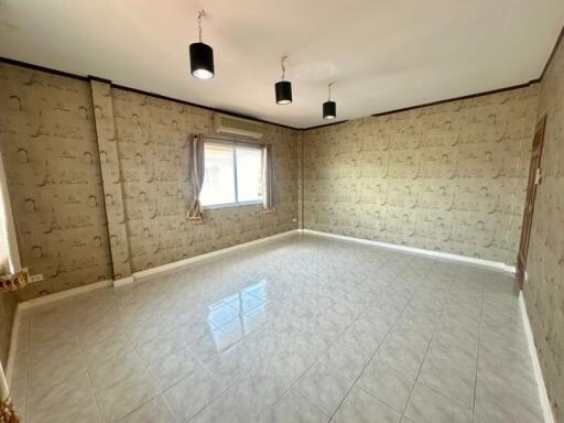 Spacious living room with tiled floor and patterned wallpaper