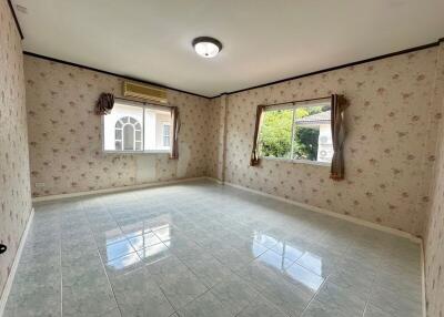 Empty bedroom with floral wallpaper and windows