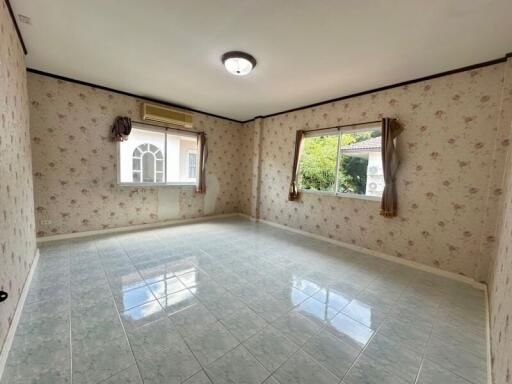 Empty bedroom with floral wallpaper and windows