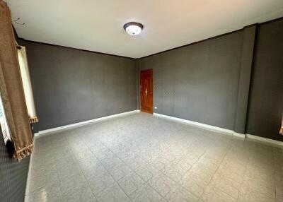 Spacious empty living room with tiled floor and a wooden door