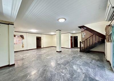 Spacious living area with staircase and marble flooring