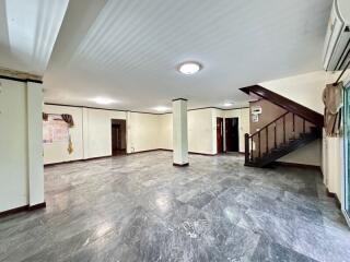 Spacious living area with staircase and marble flooring