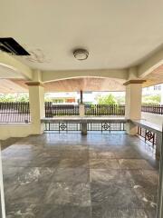 Spacious covered outdoor area with tiled flooring and ceiling light