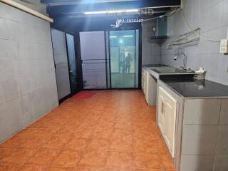 Modern kitchen with tiled floor and large windows for natural light