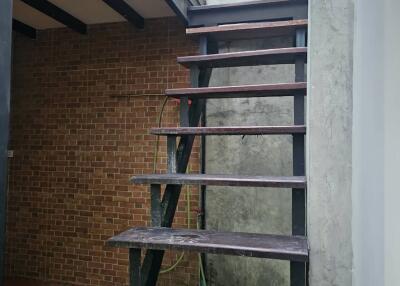 Exposed wooden staircase with brick wall