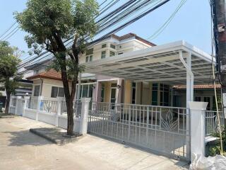 Front view of a modern house with a carport and trees