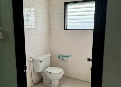 Simple bathroom with white tiles and a toilet