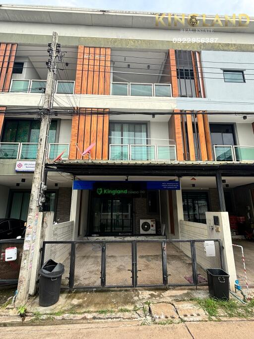 Front view of a three-story modern commercial building with balconies