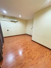 Spacious bedroom with wooden flooring and split air conditioning