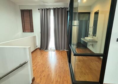 Modern hallway with wooden flooring, glass walls and a staircase