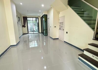 Spacious and modern main living area with tiled floor, glass stair railing and abundant natural light