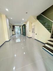 Spacious and modern main living area with tiled floor, glass stair railing and abundant natural light