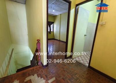 Interior hallway with stairwell and adjacent room