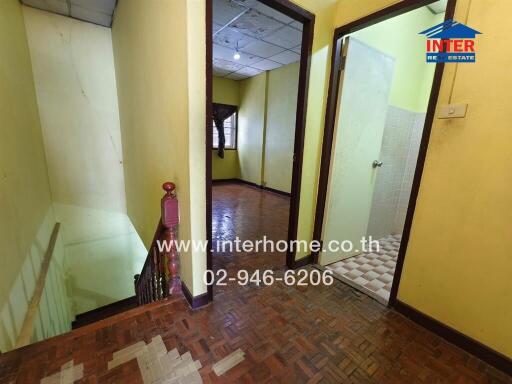 Interior hallway with stairwell and adjacent room