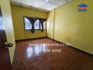 Empty bedroom with yellow walls and wooden flooring