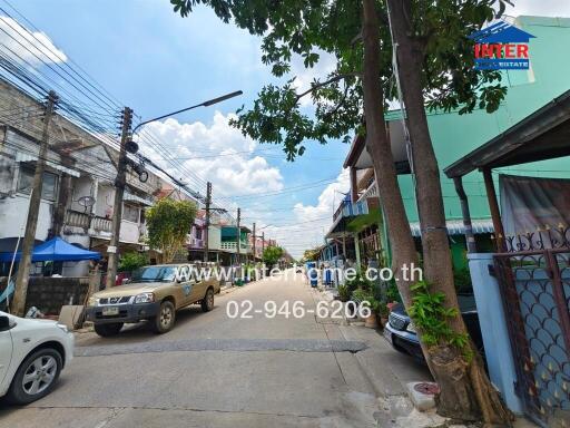 Street view of a residential area with cars parked on either side