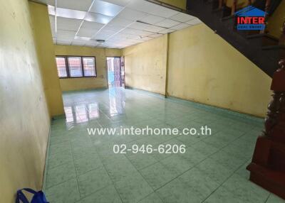 Spacious living room with tiled flooring and staircase